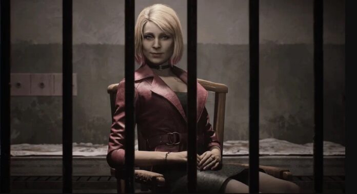 ตัวละคร Maria จากเกม Silent Hill 2 Remake นั่งอยู่หลังลูกกรงในห้องมืด สวมเสื้อแจ็กเก็ตสีแดง แสดงสีหน้าเรียบเฉย