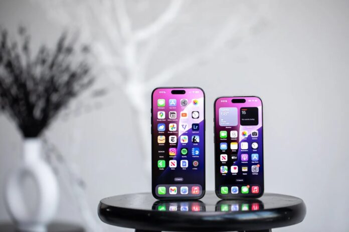 iPhone สองเครื่องวางอยู่บนโต๊ะกลม โดยแสดงหน้าจอโฮมพร้อมแอปต่าง ๆ ขณะเปิดใช้งาน