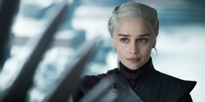 หญิงสาวผมสีเงินในชุดสีเข้ม กำลังยืนอยู่หน้าบัลลังก์เหล็กในฉากจากซีรีส์ Game of Thrones