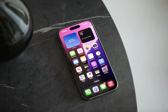 iPhone 16 Pro บนพื้นผิวหินสีดำ โชว์หน้าจอ iOS พร้อมวิดเจ็ตและแอปยอดนิยม