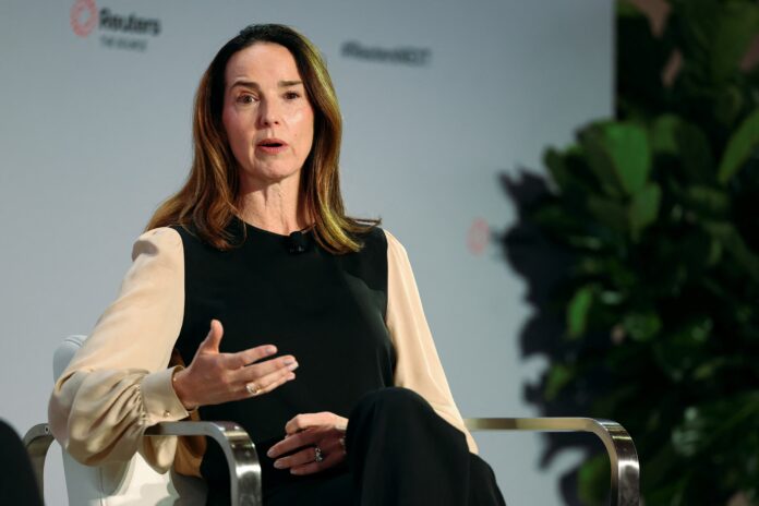 Sarah Friar ประธานเจ้าหน้าที่ฝ่ายการเงินของ OpenAI ขณะนั่งให้สัมภาษณ์บนเวทีในงานเสวนา สวมเสื้อแขนยาวสีเบจและดำ