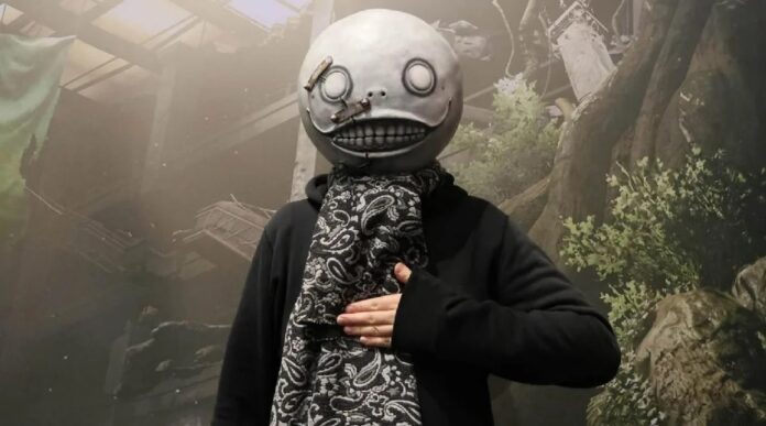 ภาพ Yoko Taro ผู้สร้างเกม NieR ยืนเอามือทาบอก