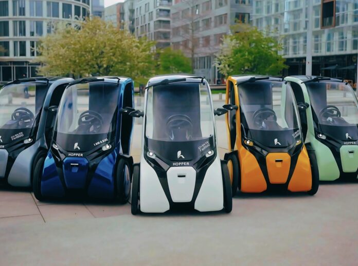 ยานยนต์สามล้อไฟฟ้าขนาดเล็ก HOPPER หลากสีจอดเรียงกันกลางเมือง