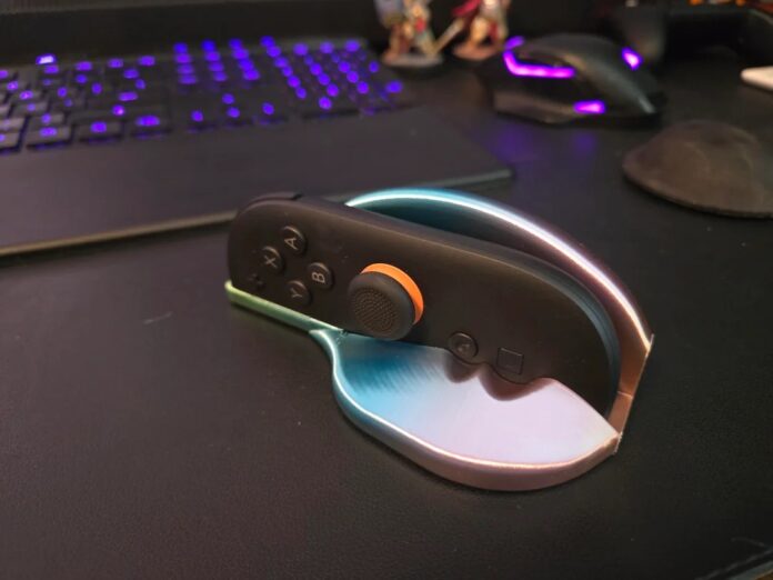 Joy-Con สีดำของ Nintendo Switch 2 วางอยู่บนแท่นเมาส์ แบบพิมพ์สามมิติที่ออกแบบมาให้พอดีกับรูปทรงจอย