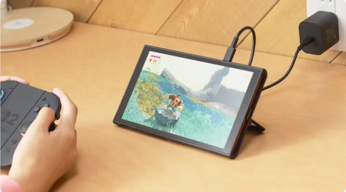 ผู้เล่นกำลังใช้จอย Switch 2 กับหน้าจอที่วางตั้งเล่นเกม ขณะชาร์จแบตเตอรี่