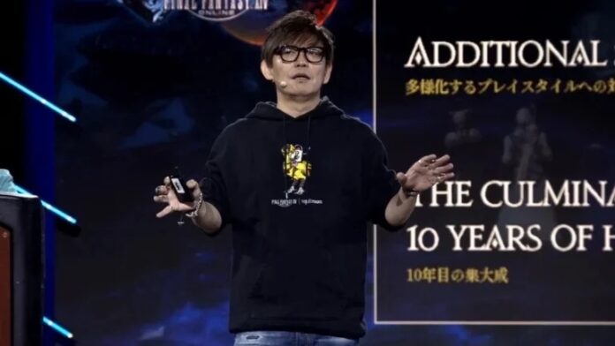 Yoshida Naoki ผู้กำกับเกม Final Fantasy XIV กำลังยืนพูดบนเวที