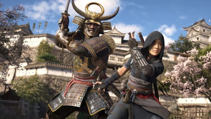 ตัวละครนักรบซามูไรและนินจาหญิงจากเกม Assassin’s Creed Shadows ยืนเตรียมพร้อมต่อสู้หน้าปราสาทญี่ปุ่นโบราณในฤดูซากุระบาน