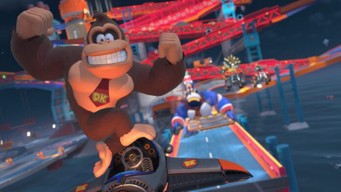 Donkey Kong กระโดดขึ้นรถแข่งจากเกม Mario Kart World พร้อมฉากหลังสนามแข่ง