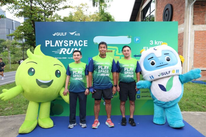 ผู้บริหารยืนถ่ายภาพร่วมกันบริเวณงาน “GULF x AIS PLAYSPACE RUN” ที่สวนเบญจกิติ โดยมีมาสคอตสีเขียวของ AIS และมาสคอตหุ่นยนต์สีฟ้าขาวของ GULF ยืนอยู่ด้านข้างทั้งสองฝั่ง ในบรรยากาศสดใสและเป็นกันเอง