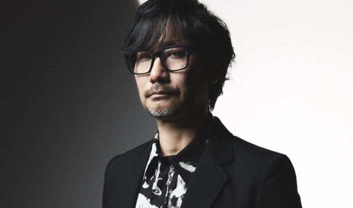ภาพ Hideo Kojima ทำหน้าเคร่งขรึมในชุดโทนสีดำ
