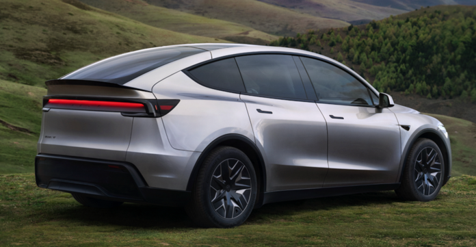 ภาพ Tesla Model Y L รถ SUV ไฟฟ้า 6 ที่นั่งรุ่นใหม่จาก Tesla สีเงิน จอดอยู่บนพื้นหญ้าท่ามกลางภูเขา แสดงดีไซน์หลังคาแบบลาด กระจกสีเข้ม พร้อมล้ออัลลอยลายใหม่