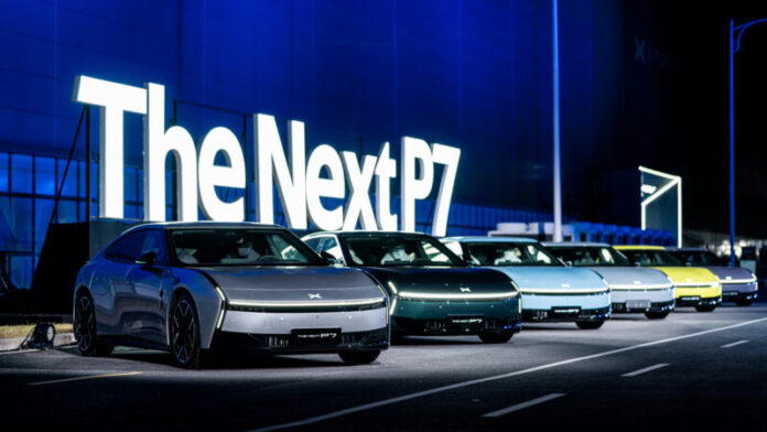 ภาพรถยนต์ไฟฟ้า Xpeng P7 รุ่นใหม่จอดเรียงกันหน้าป้าย “The Next P7” ในบรรยากาศกลางคืน พร้อมแสงไฟสีน้ำเงินสะท้อนตัวถังรถที่มีหลายสี แสดงถึงความล้ำสมัยของดีไซน์และเทคโนโลยีในเจเนอเรชันใหม่ของ Xpeng P7