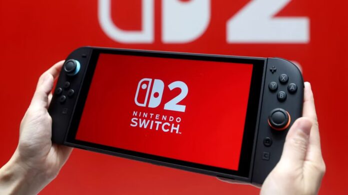 ภาพมือกำลังถือเครื่อง Nintendo Switch 2 ที่มีหน้าจอแสดงโลโก้ “Nintendo Switch 2” พื้นหลังสีแดง