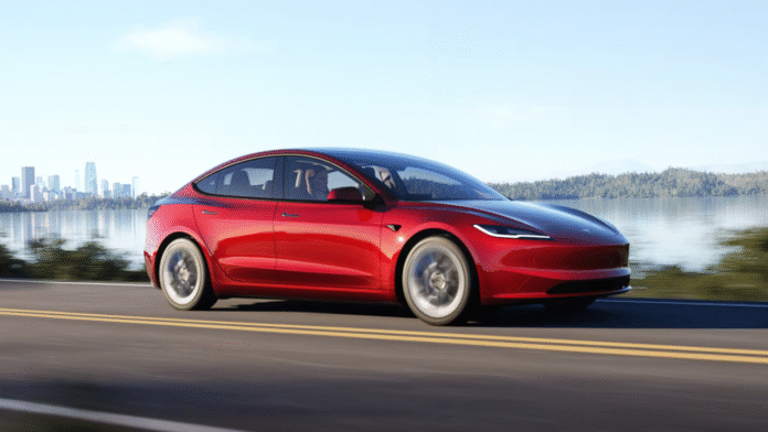 Tesla Model 3 สีแดง รถยนต์ไฟฟ้า ขับเคลื่อนบนถนนริมทะเลสาบในบรรยากาศกลางแจ้ง