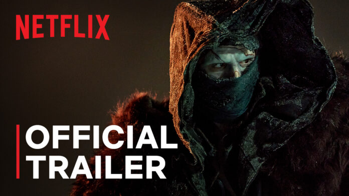ภาพตัวอย่างจากภาพยนตร์ Netflix แฟรงเกนสไตน์ สวมฮู้ดคลุมศีรษะและผ้าปิดหน้าในบรรยากาศมืดหม่น