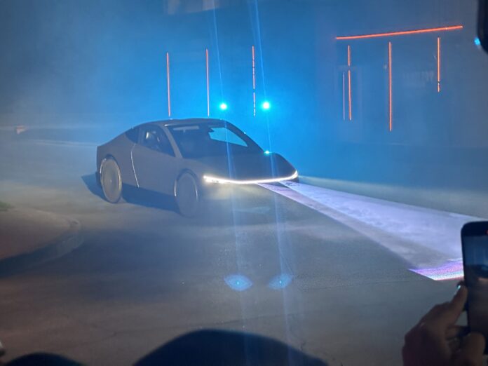 รถ Tesla Cybercab เปิดไฟหน้า จอดอยู่ในงานเปิดตัว