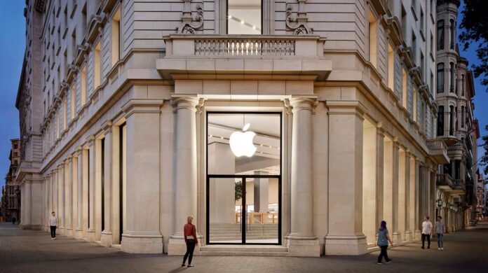 ด้านหน้าร้าน Apple Passeig de Gràcia ในบาร์เซโลนา มุมอาคารหินสีอ่อนพร้อมโลโก้ Apple ขนาดใหญ่บนกระจกหน้าร้าน