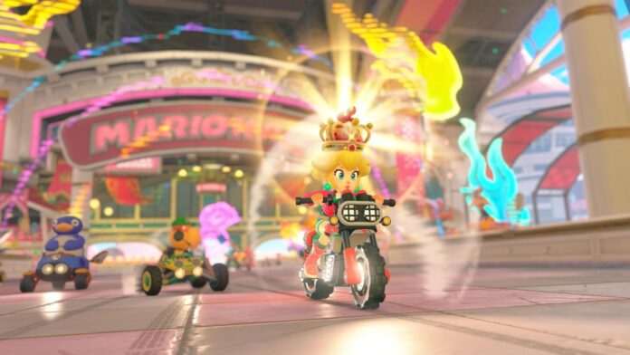 ฉากการแข่งขันในเกม Mario Kart World บน Nintendo Switch 2 รถแข่งกำลังเร่งความเร็วบนสนาม พร้อมตัวละครจากซีรีส์ Mario ท่ามกลางเอฟเฟกต์แสงสี