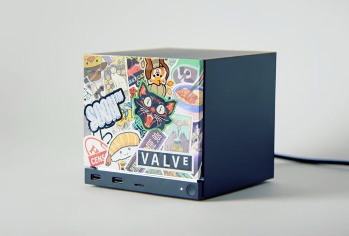 Steam Machine ของ Valve ตกแต่งด้วยสติกเกอร์หลากหลายแบบ วางอยู่บนพื้นหลังสีเทา