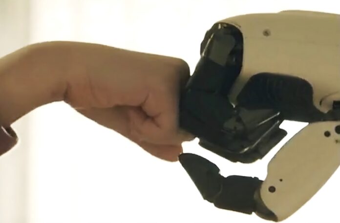 แขนกลของหุ่นยนต์ LG CLOiD สัมผัสหมัดของมนุษย์ แสดงถึงการโต้ตอบระหว่างหุ่นยนต์ผู้ช่วยภายในบ้านกับผู้ใช้งาน