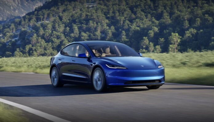 รถยนต์ไฟฟ้า Tesla สีฟ้า กำลังขับอยู่บนถนนฉากหลังเป็นภูเขา