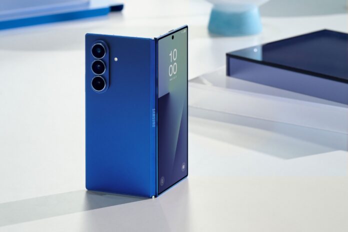 สมาร์ตโฟนจอพับ Samsung Galaxy Z Fold ตั้งวางบนโต๊ะ แสดงดีไซน์ฝาหลังและโมดูลกล้องสามตัว