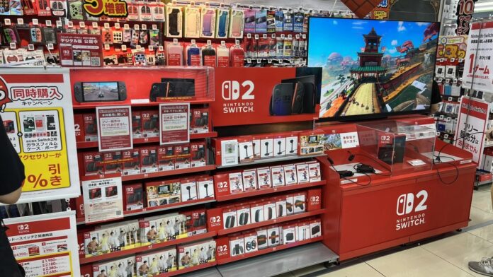 มุมจำหน่าย Nintendo Switch 2 ในร้านเกมที่ญี่ปุ่น พร้อมเครื่องเดโม หน้าจอโฆษณา และอุปกรณ์เสริมวางเรียงบนชั้นวางสินค้า