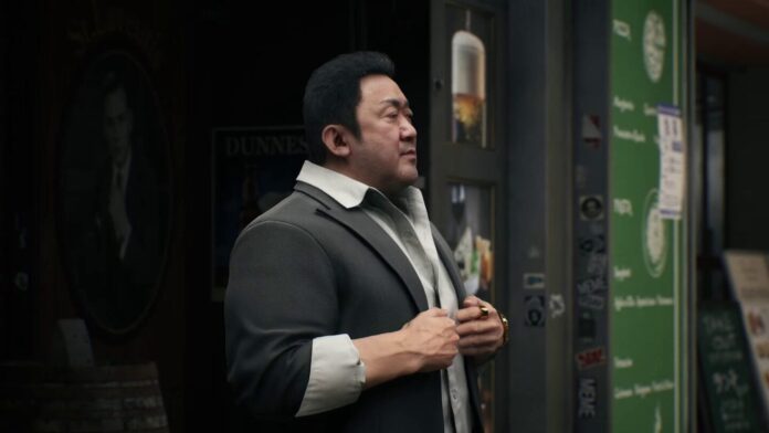 ตัวละครชายสวมสูทยืนจับปกเสื้ออยู่หน้าตู้ในเกม GANG OF DRAGON