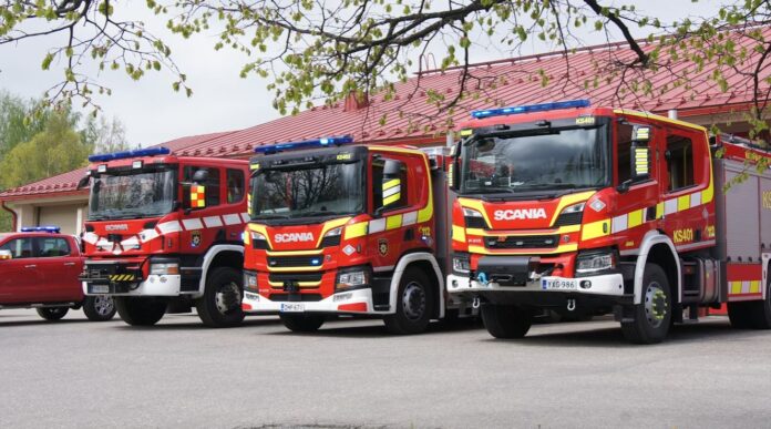 รถดับเพลิงสีแดงหลายคันจอดเรียงกันหน้าสถานีดับเพลิง