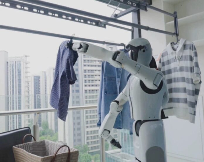 หุ่นยนต์ AI Shiguang S1 กำลังแขวนเสื้อผ้าบนราวในระเบียงห้องพัก