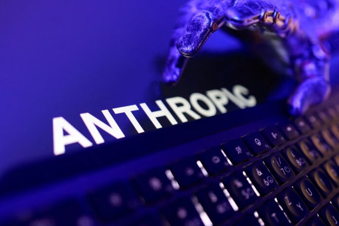 โลโก้ Anthropic บนหน้าจอคอมพิวเตอร์ พร้อมภาพมือหุ่นยนต์โทนสีม่วง