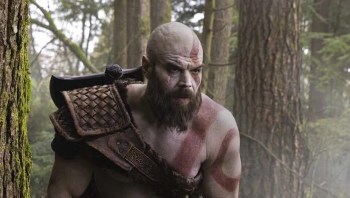 Ryan Hurst ในบท Kratos สวมเกราะหนังยืนอยู่กลางป่า
