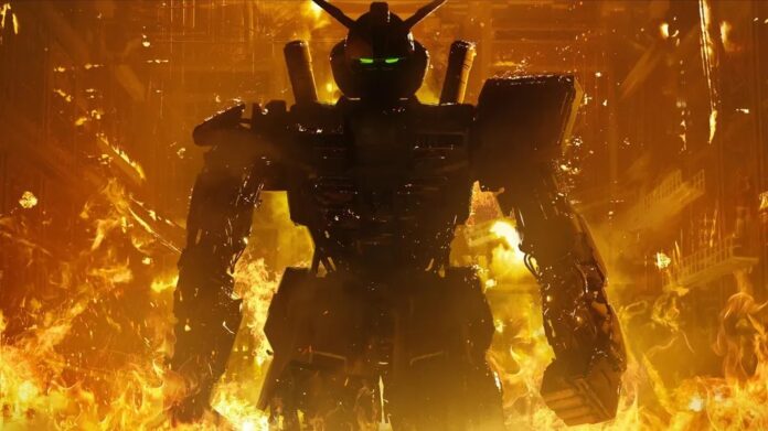หุ่นยนต์ Gundam ยืนอยู่ท่ามกลางกลุ่มควันและเปลวไฟสงคราม