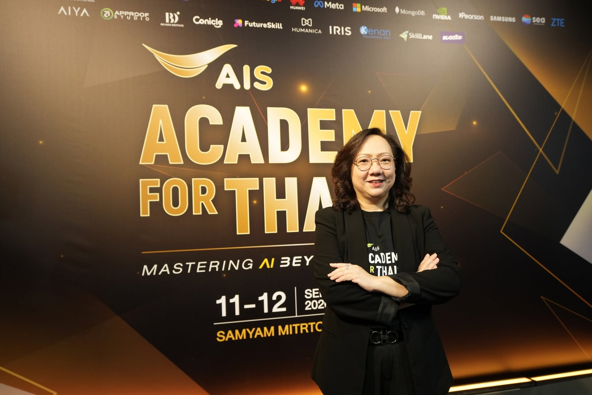 กานติมา เลอเลิศยุติธรรม ถ่ายภาพบริเวณป้ายงาน AIS ACADEMY For THAIs 2026