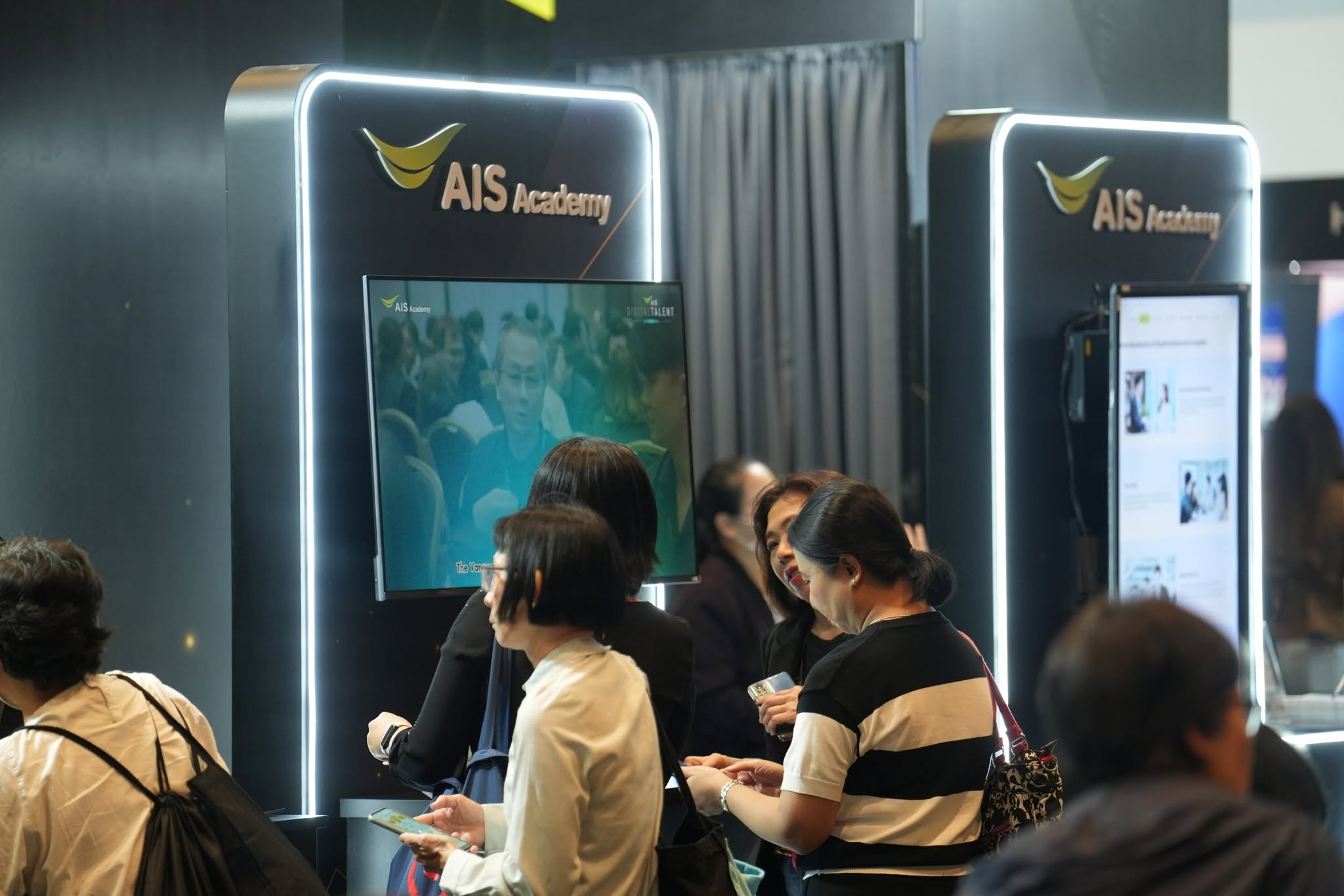 ผู้ร่วมงานทดลองเทคโนโลยีบริเวณบูธ AIS Academy