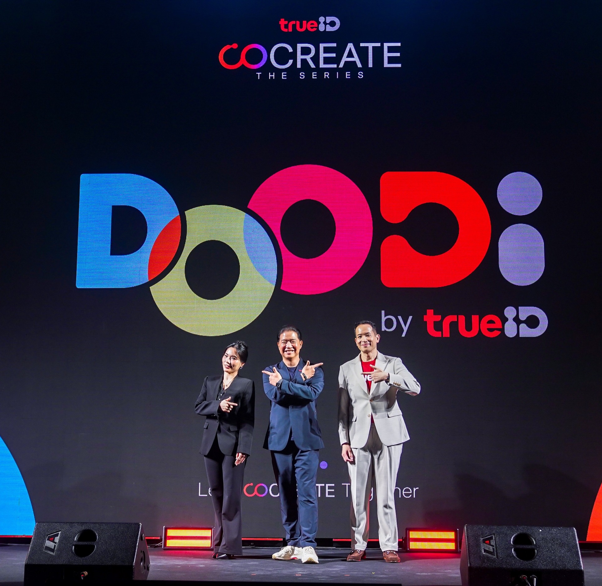 กลุ่มผู้บริหาร 3 คนยืนบนเวทีใต้โลโก้ DOODi