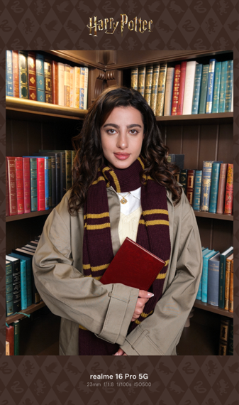 หญิงสาวในธีม Harry Potter ถือหนังสือหน้าชั้นหนังสือ ถ่ายด้วย realme 16 Pro 5G