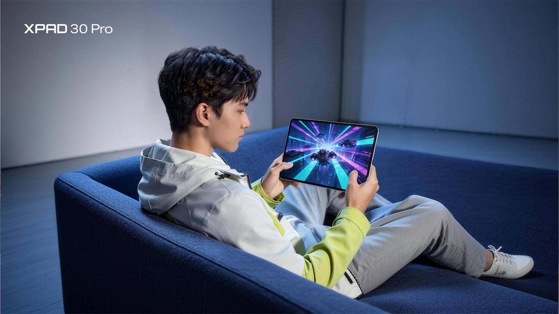 ผู้ใช้นั่งเล่นเกมบน Infinix XPAD 30 Pro บนโซฟา