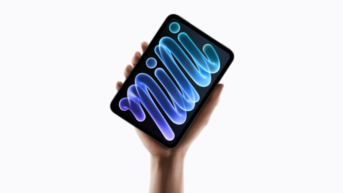 iPad mini สีมิดไนท์พร้อมจอ OLED ถืออยู่ในมือ