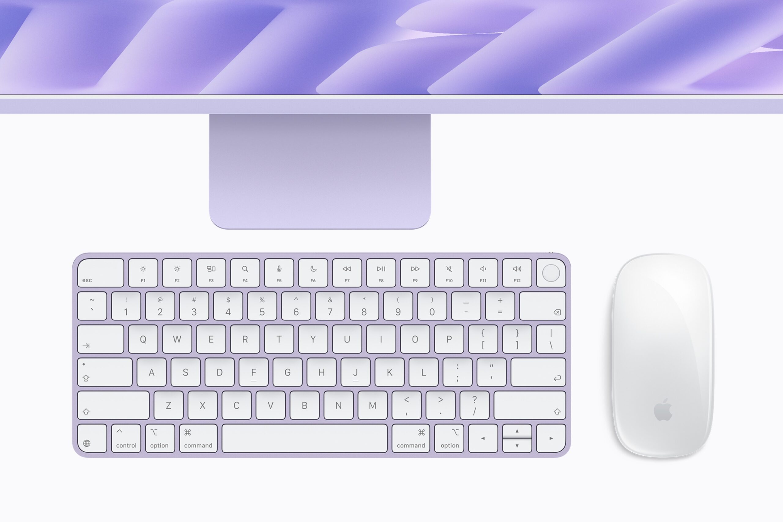 คีย์บอร์ดและเมาส์สีม่วงอ่อนวางอยู่ด้านหน้า iMac สีเดียวกัน