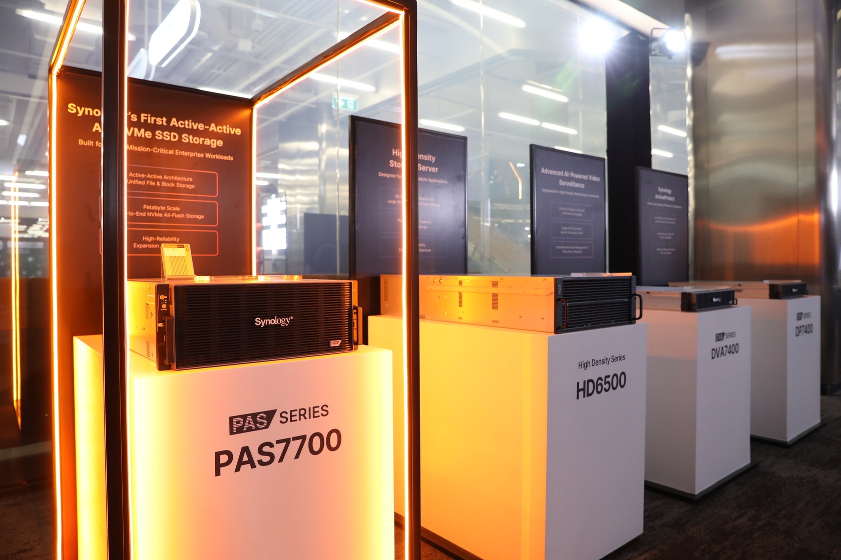 อุปกรณ์ Synology PAS7700 และ DVA7400 พร้อมอุปกรณ์อื่นบนแท่นจัดแสดงในงาน
