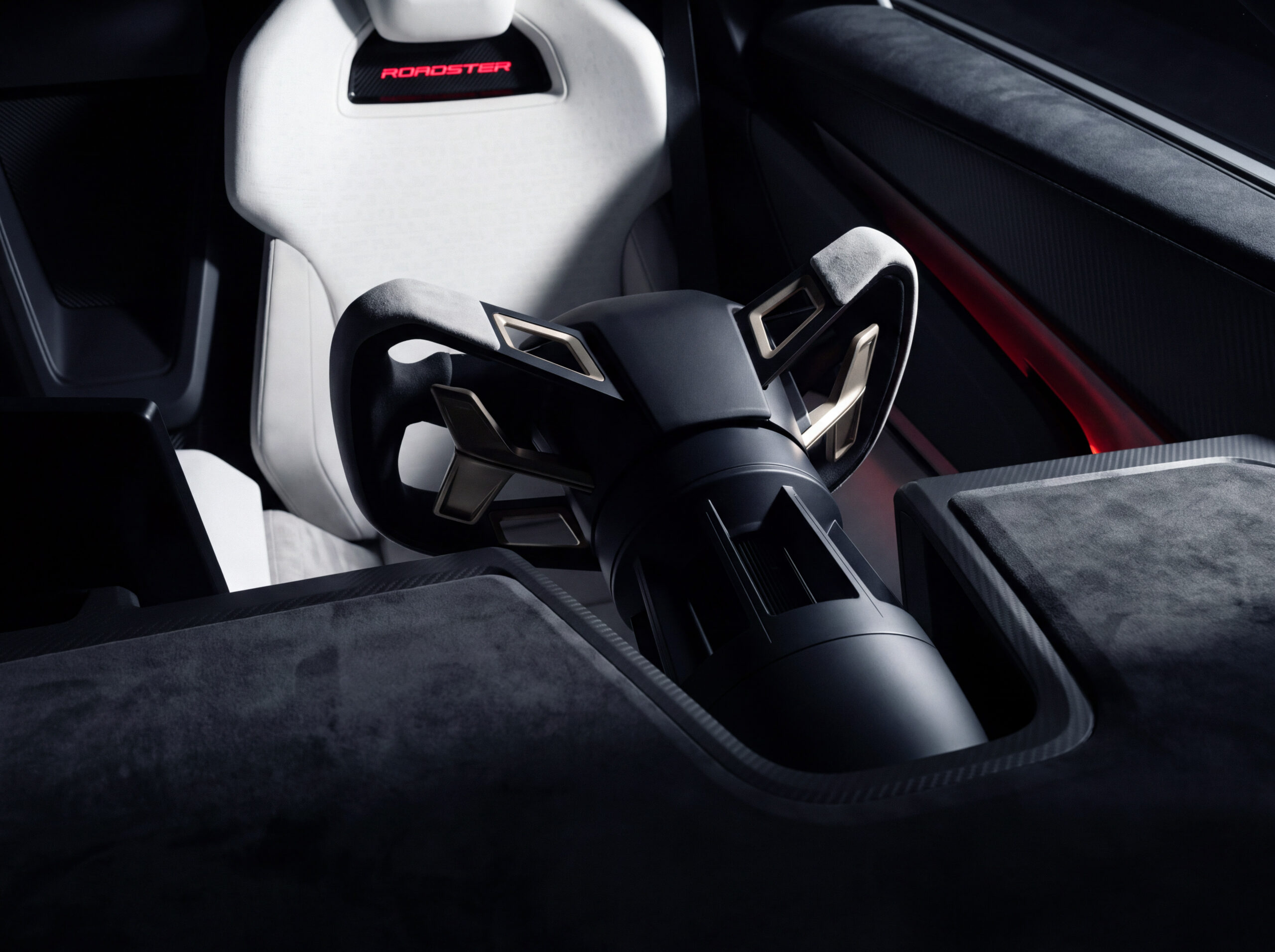 มุมใกล้ของพวงมาลัย Roadster และเบาะสีขาว