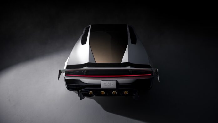 Roadster สีขาวมองจากด้านท้าย เห็นสปอยเลอร์ ไฟท้ายแนวยาว และช่องกลมสีทองสี่ช่อง
